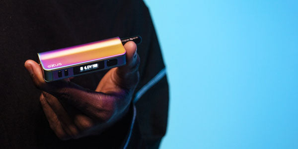 Man holding Exxus Snap VV Pro in front of light blue studio background