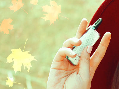Woman in red hat holding Exxus Minovo in front of forest with leaves falling