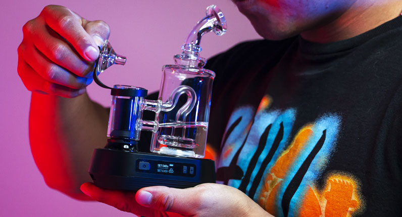 Man holding the Exxus Go Plus inside studio with red lighting