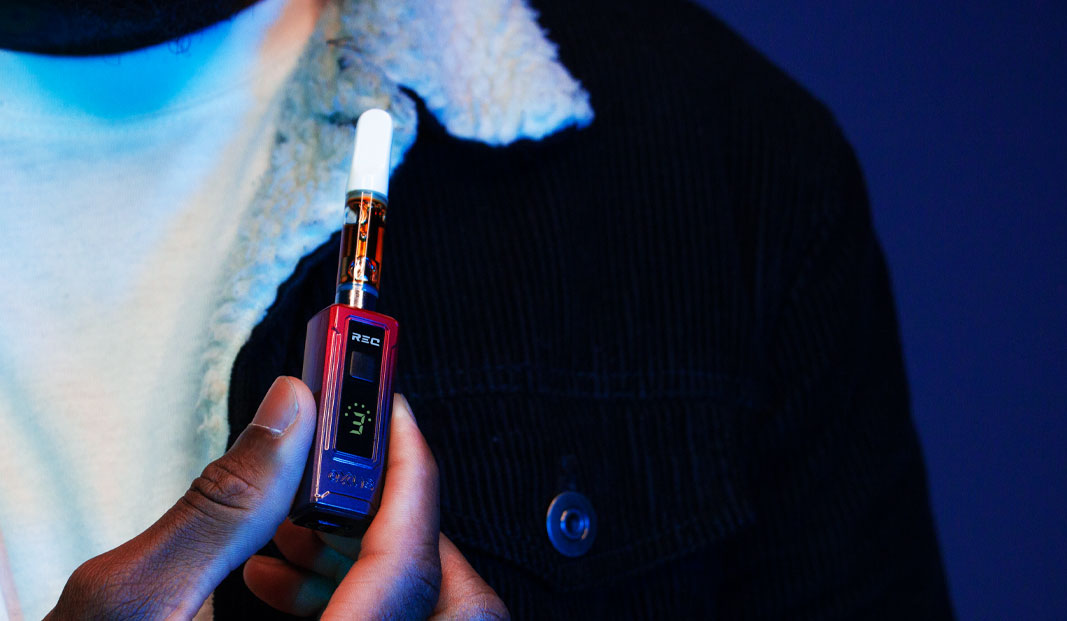 Person holding Exxus REC in front of blue studio background