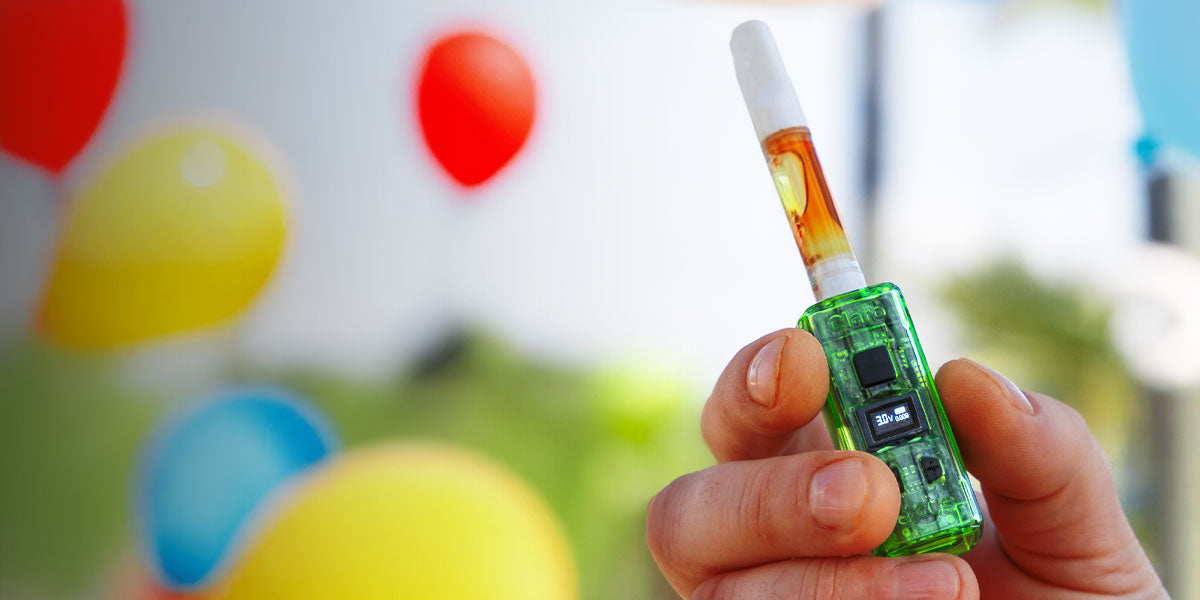 Man holding Exxus Claro in front of celebratory balloons