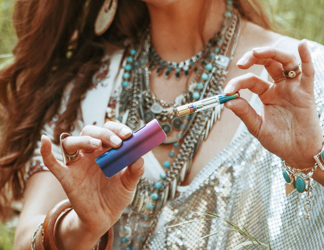 Woman holding cartridge apart of Exxus Snap VV in front of forest clearing