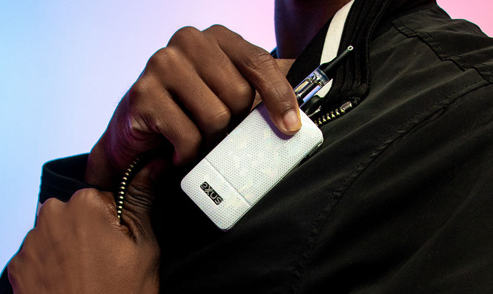 Hand slipping a white Exxus Push 510 thread battery into a jacket pocket