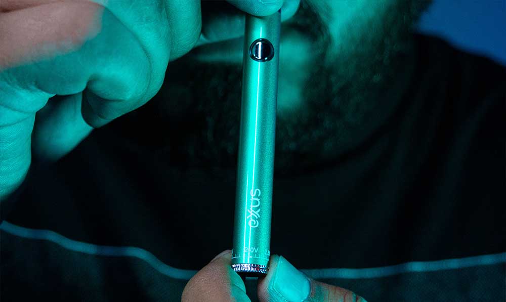 Person holding a teal Exxus Twistr 510 thread battery