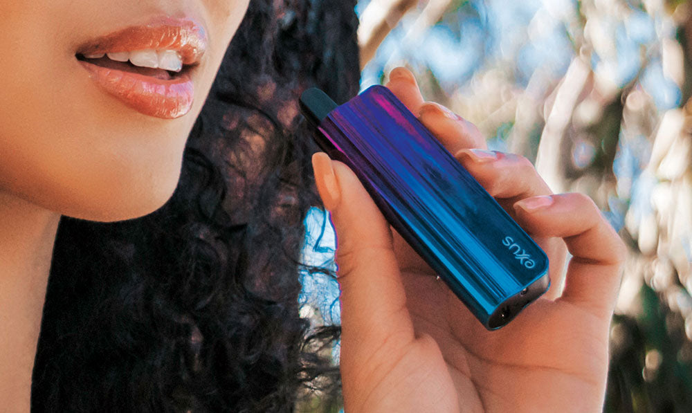 Person holding a blue and purple Exxus Snap VV 510 thread battery