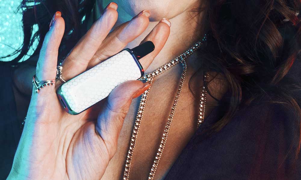 Exxus MiNovo in woman's hands with blue background