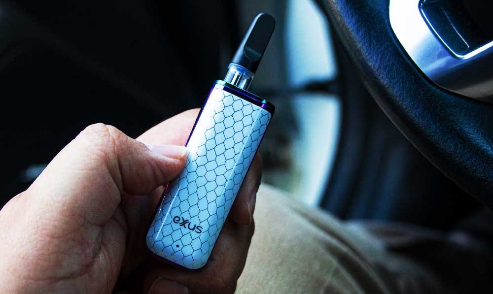 Exxus MiNovo in hand in a car near the steering wheel