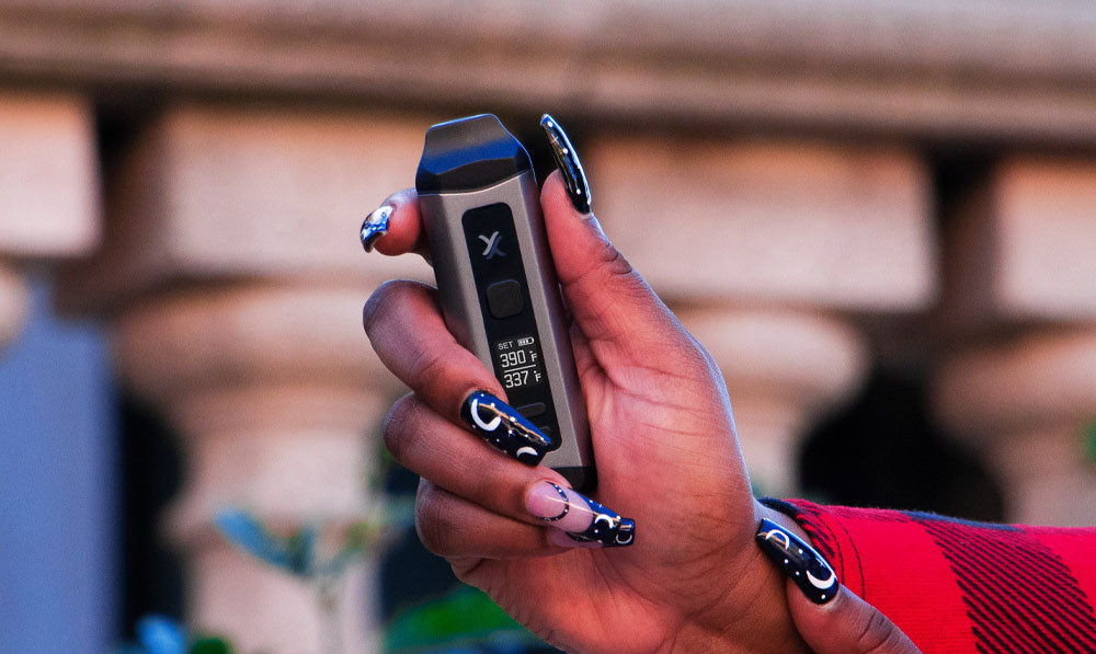 Woman holding Exxus Mini Plus in front of wall