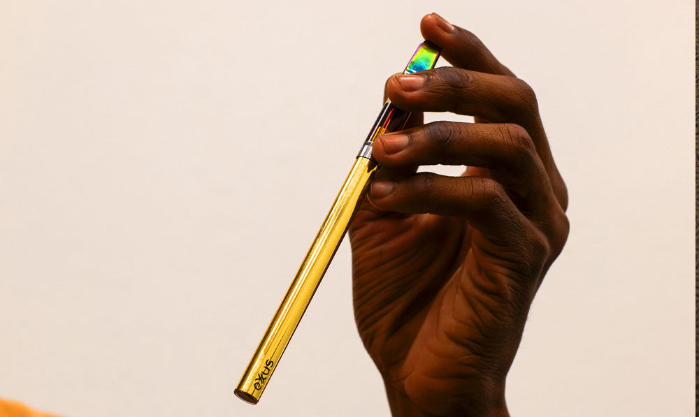Man holding Gold Exxus Tap VV 2.0 in front of white background