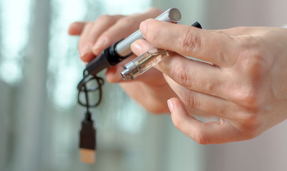 Person preparing to charge their vape