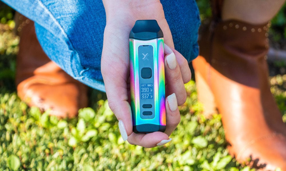 Woman in boots holding Exxus Mini Plus under sunshine