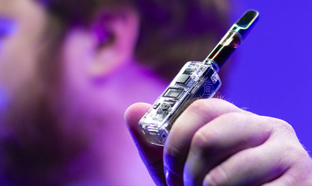 Man holding Exxus Claro in front of purple studio background