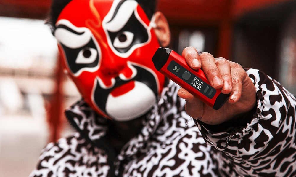Man with themed mask and jacket holding Exxus Mini Plus