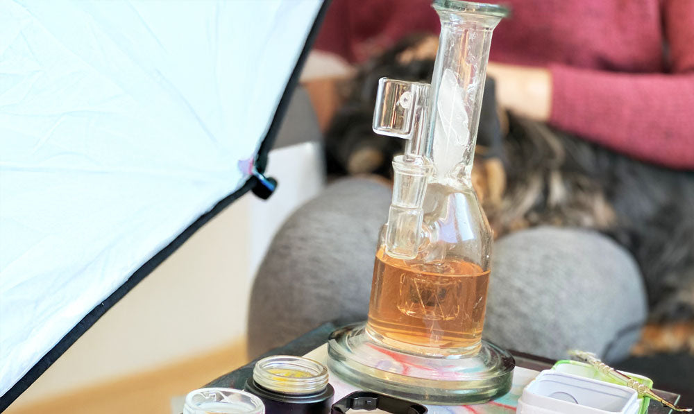 Woman sitting with prepared dab rig in a chair at a photo studio