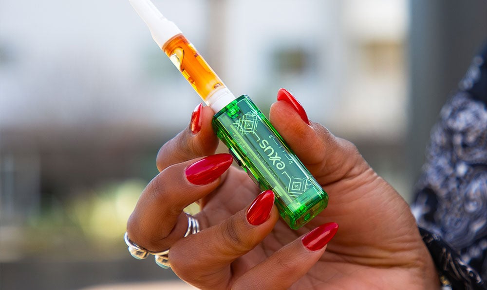 Woman with red nails holding the Exxus Claro at park