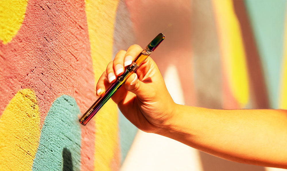 Woman holding Exxus Twistr 2 near pastel wall