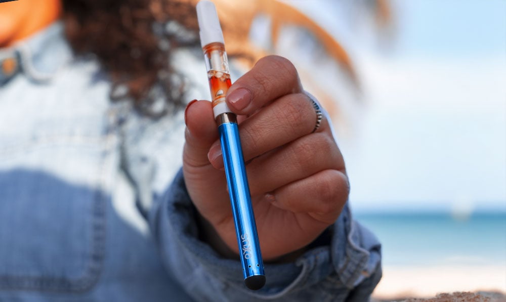 Woman holding Exxus Slim 2.0 by the beach