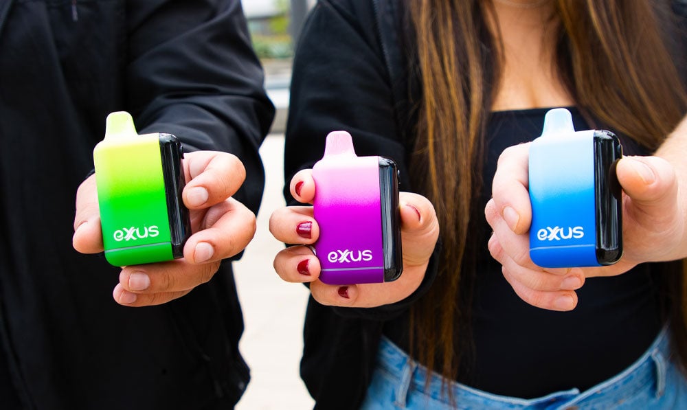 Three people each holding an Exxus Snap DLX outside during the daytime