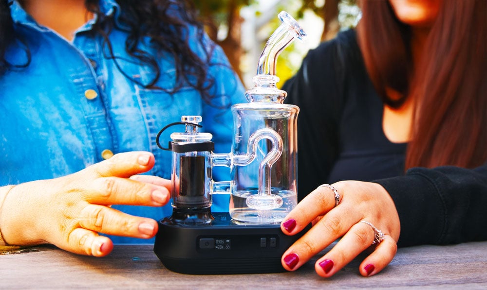 Two women with Exxus Go Plus on a park bench during the daytime