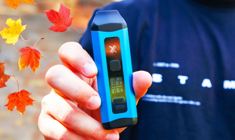 Man holding Mini Plus with autumn leaves falling