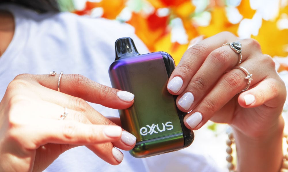Woman holding Exxus Snap DLX in front of fall trees