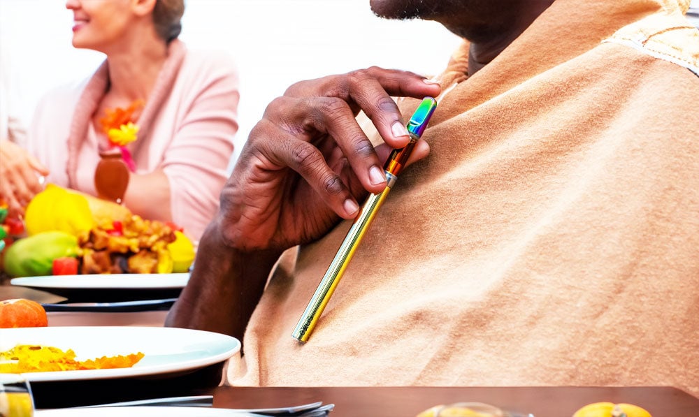 Man holding Exxus Tap VV 2 at Thanksgiving dinner with family in the background