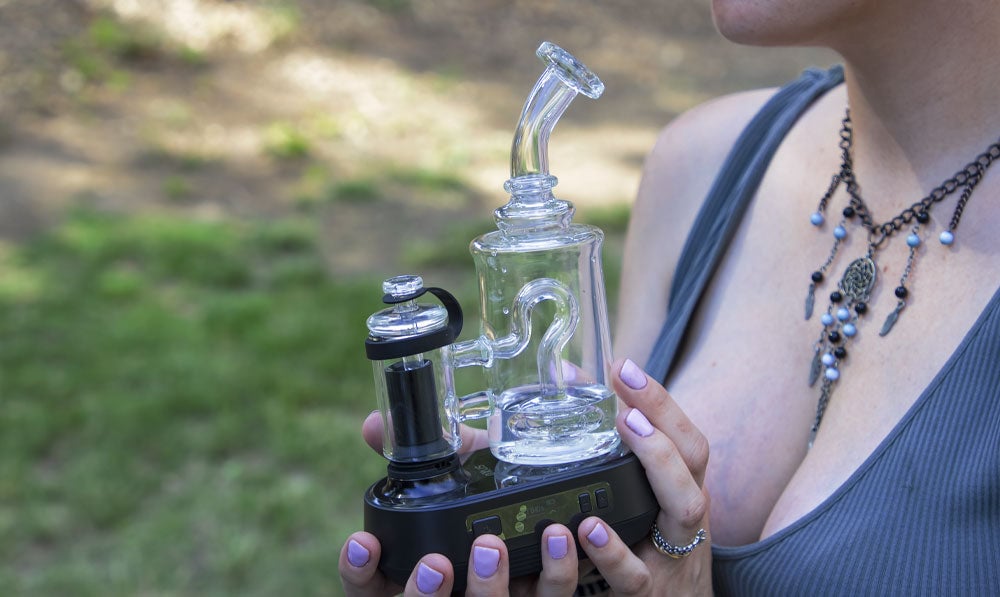 Person holding a Puffco Peak Go on a nature trail
