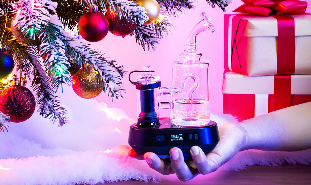 Hand holding Exxus Go Plus in front of Christmas tree