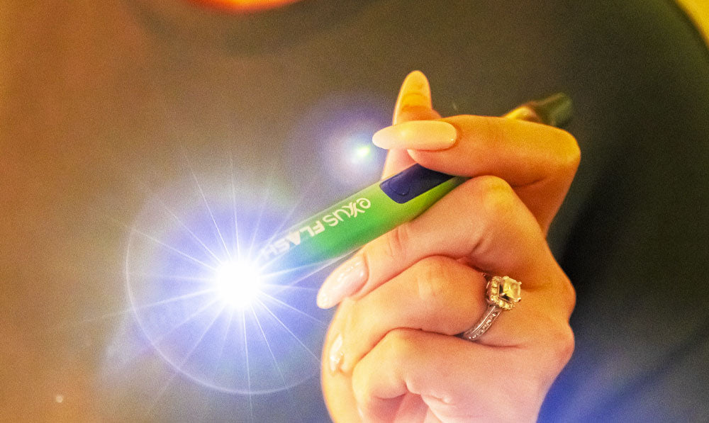 Woman holding Exxus Flash with flashlight on