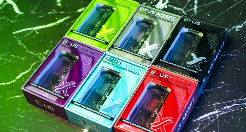 Exxus Adapt units resting in packaging on top of lightning themed display with soft green lighting