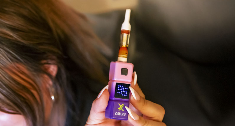 Person holding an Exxus Stax 510 thread battery with a cartridge attached