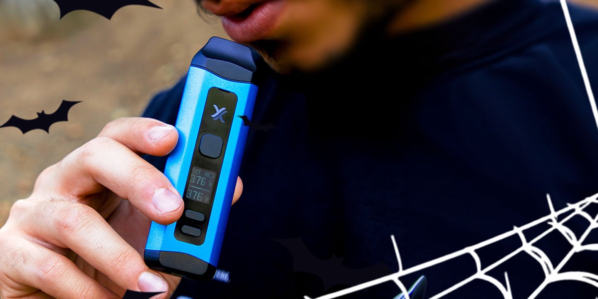 man holding exxus mini plus dry herb vaporizer with halloween vector images