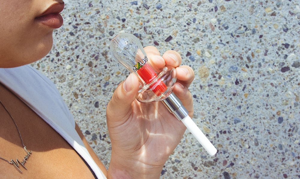 woman holding the Exxus Nectar collector near building